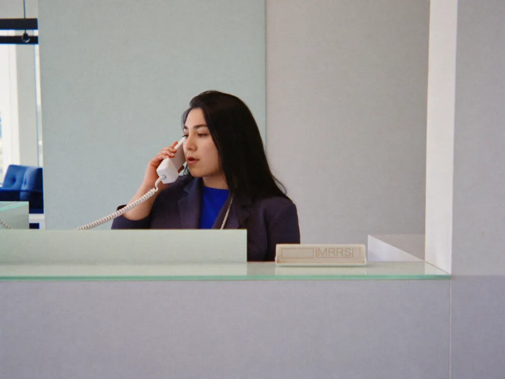 Imagen ilustrativa: una recepcionista al teléfono con gesto de duda