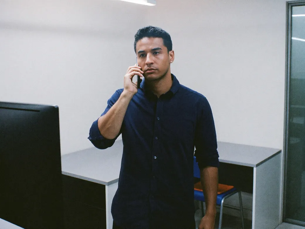Imagen ilustrativa: un técnico al teléfono frente a un monitor oscuro en un cuarto de servidores
